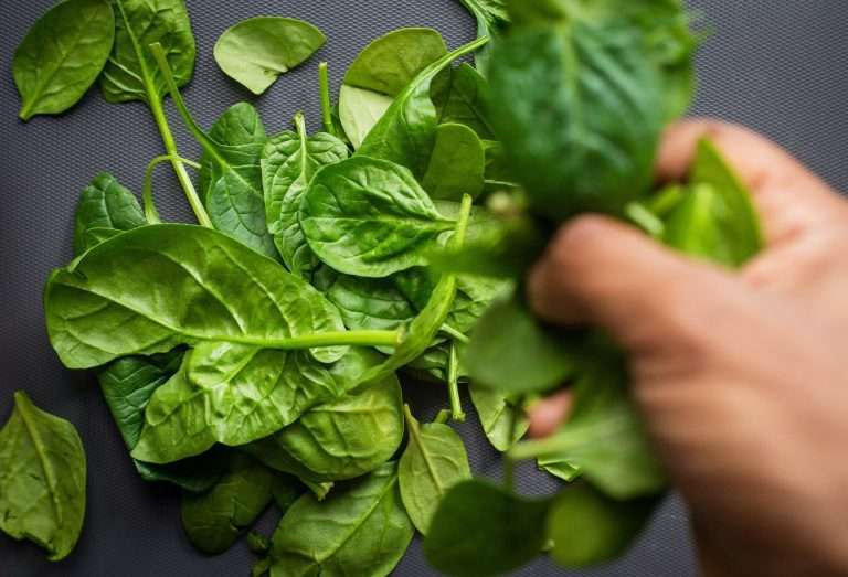 person picking up spinach