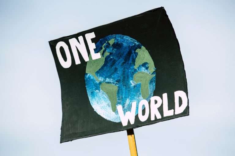 poster that reads one world with a drawing of the earth