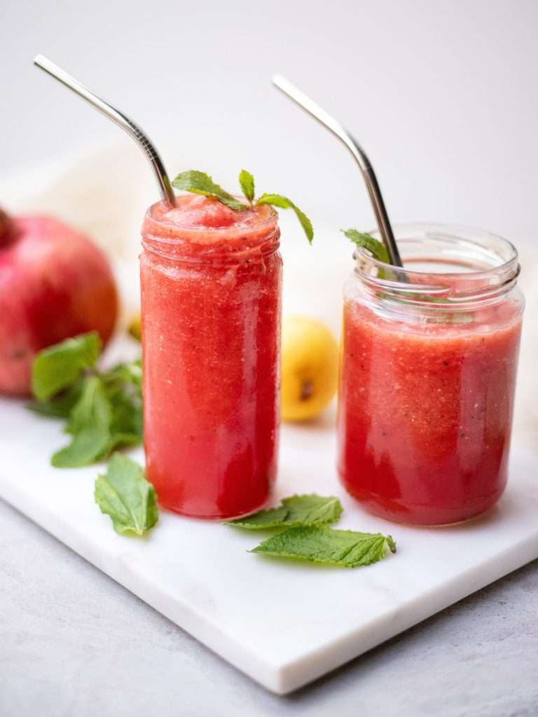 2 watermelon smoothies with straws in them