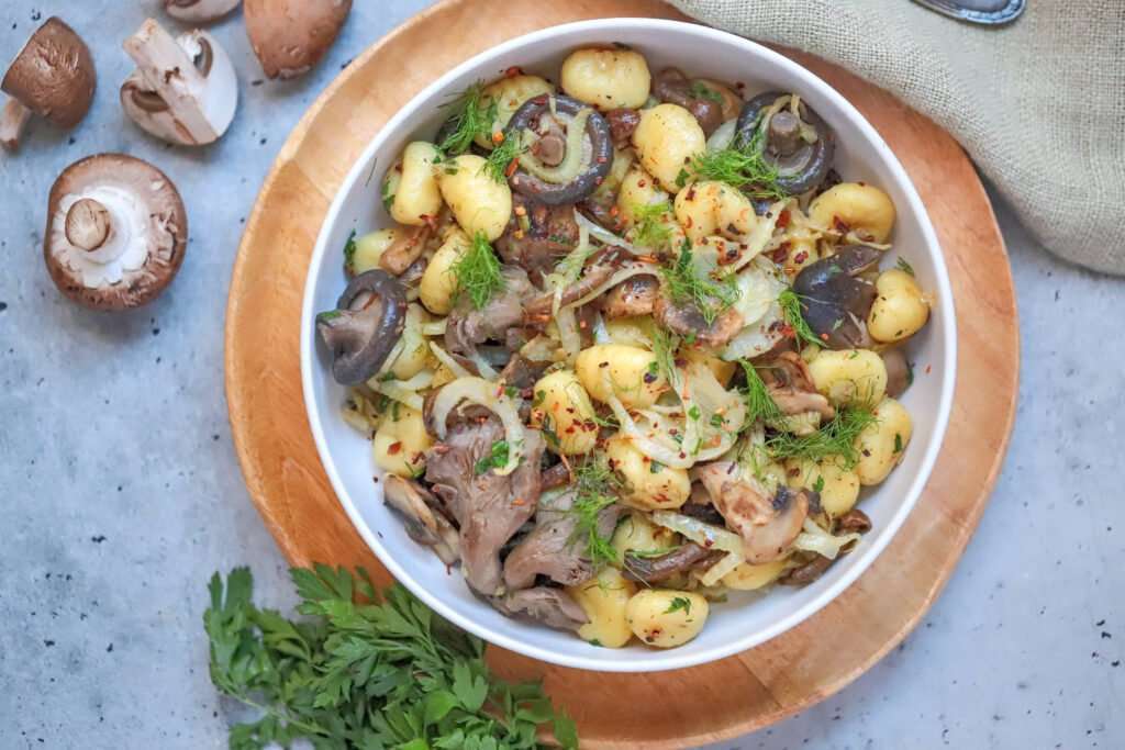 Vegan gnocchi with fennel and mushrooms in a white bowl